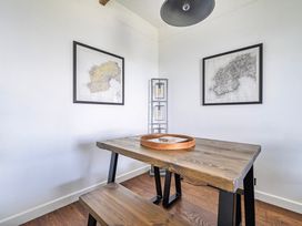 A dining room with a wooden table and maps on the walls at Cape View Cape Cornwall near St Just