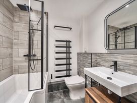 A bathroom with a shower, bathtub, toilet, and sink at Cape View near St Just