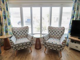 Two patterned chairs and a table with a view through the window at 7 Longstone Close Chathill