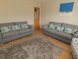 A living room with sofas and a door at 7 Longstone Close Chathill