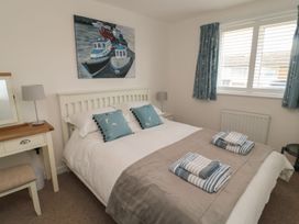A bedroom with a bed, table, and artwork at 7 Longstone Close in Chathill