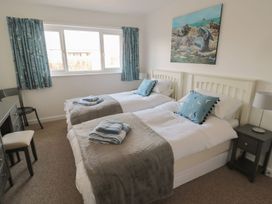 A bedroom with twin beds and a desk at 7 Longstone Close Chathill