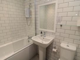 A bathroom with a bathtub, sink, and toilet at 7 Longstone Close Chathill