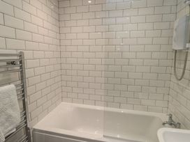 A bathroom with a bathtub and shower at 7 Longstone Close in Chathill