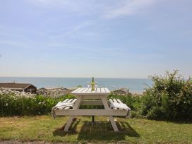 A table with a bottle and glasses overlooking the sea at Salt & Stone Lyme Regis