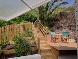 A wooden deck area with chairs and stairs at Salt & Stone Lyme Regis