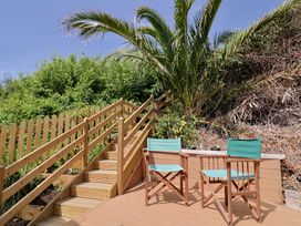 Two wooden chairs and a table beside stairs at Salt & Stone in Lyme Regis