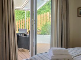 A bedroom with a door leading to an outdoor seating area at Salt & Stone in Lyme Regis