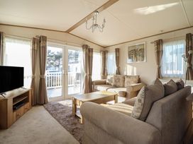 A living room with a sofa and television at 23 Gull Court in Porthmadog