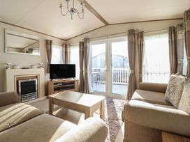 A living room with a television and a coffee table at 23 Gull Court in Porthmadog