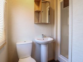 A bathroom with a toilet and a sink at 23 Gull Court in Porthmadog