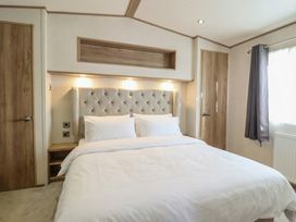 A bedroom with a bed and door at 23 Gull Court in Porthmadog