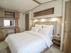 A bedroom with a bed and desk in 23 Gull Court Porthmadog