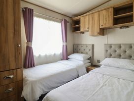 A bedroom with two beds and a window at 23 Gull Court in Porthmadog