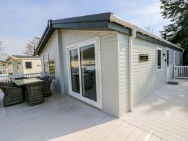 A house with a deck and outdoor furniture at Dukes Meadow in Carmarthen