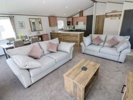 A living room with sofas and a dining setup at Dukes Meadow in Carmarthen