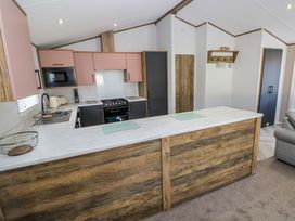 A kitchen with modern appliances and a kitchen island at Dukes Meadow in Carmarthen
