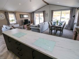 A living room with a dining area and television at Dukes Meadow in Carmarthen