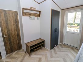 A hallway with a bench and hooks at Dukes Meadow in Carmarthen
