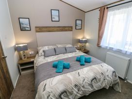 A bedroom with a bed and lamps at Dukes Meadow in Carmarthen