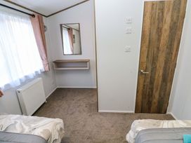 A bedroom with a mirror and shelf at Dukes Meadow in Carmarthen