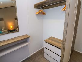 A bedroom with a wardrobe area and a mirror at Dukes Meadow in Carmarthen