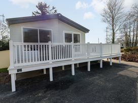 A house with a deck and railing at Dukes Meadow in Carmarthen