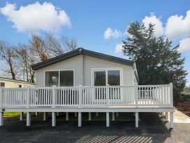 A house with a deck and trees at Dukes Meadow Carmarthen
