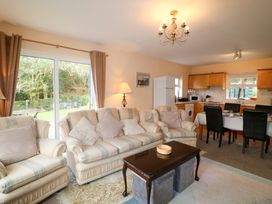 A living room with a sofa and dining area at Lugdine Lodge in Glengarriff