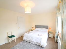 A bedroom with a bed and chairs at Lugdine Lodge in Glengarriff