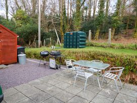 An outdoor area with a table and chairs and grills at Lugdine Lodge in Glengarriff
