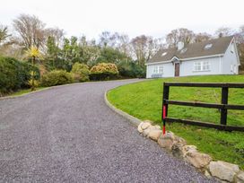 An exterior view of a house with a gravel driveway at Lugdine Lodge, Glengarriff