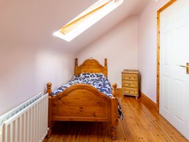 A bedroom with a wooden bed and nightstand at Ballyneill Farmhouse, Carrick-On-Suir, County Tipperary