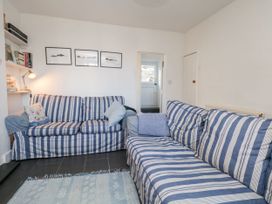 A living room with sofas and a bookshelf at Burnside Cottage in Grange-Over-Sands