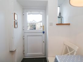 A hallway with a door and a window at Burnside Cottage in Grange-Over-Sands