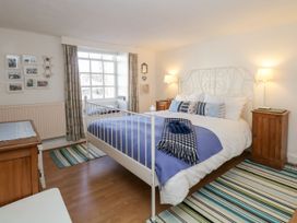 A bedroom with a bed and decorative items at Burnside Cottage in Grange-Over-Sands
