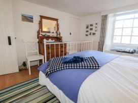 A bedroom with a bed, mirror and dresser at Burnside Cottage in Grange-Over-Sands
