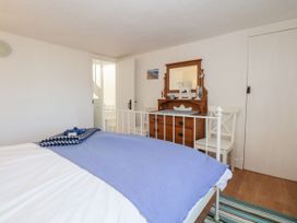 A bedroom with a bed and dresser at Burnside Cottage in Grange-Over-Sands