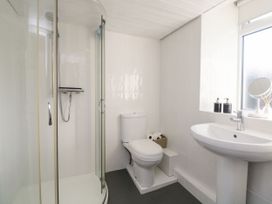 A bathroom with a shower, toilet, and sink at Burnside Cottage, Grange-Over-Sands