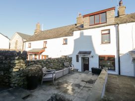A garden with stone wall and outdoor furniture at Burnside Cottage Grange-Over-Sands