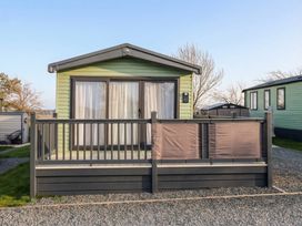 A cabin with a deck and railing at Lodge 22, Moselle in Malton