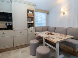 A dining room with a table and sofa at Lodge 22, Moselle in Malton