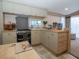 A kitchen with cabinets and appliances at Lodge 22, Moselle in Malton