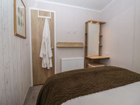 A bedroom with a bed and mirror at Lodge 22, Moselle in Malton