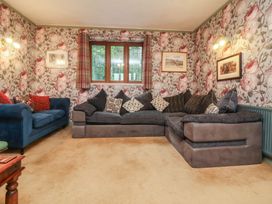 A living room with a sectional sofa and pictures on the walls at West Down Country House in South Molton
