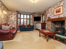 A living room with sofas, a coffee table, and a fireplace at West Down Country House in South Molton
