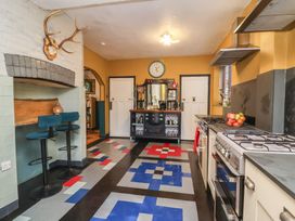 A kitchen with bar stools and appliances at West Down Country House in South Molton