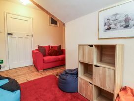 A seating area with a red sofa and wooden shelf at West Down Country House South Molton