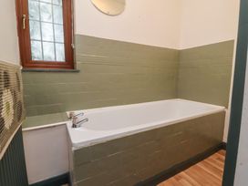 A bathroom with a bathtub and window at West Down Country House in South Molton