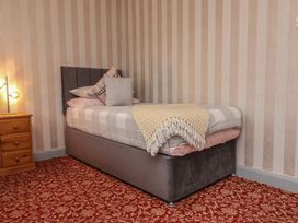A bedroom with a single bed and wooden bedside table at West Down Country House in South Molton